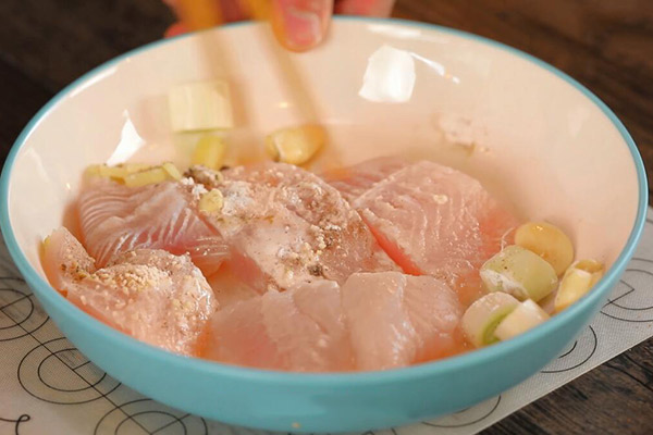 2.鱼肉中加入油,姜块,葱段和蒜,再放入适量调料翻拌均匀.1.