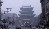 古城开封再现雪花飞舞  路上行人雪中前行