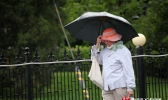 北京清晨风伴雨气温骤降 市民长袖出行